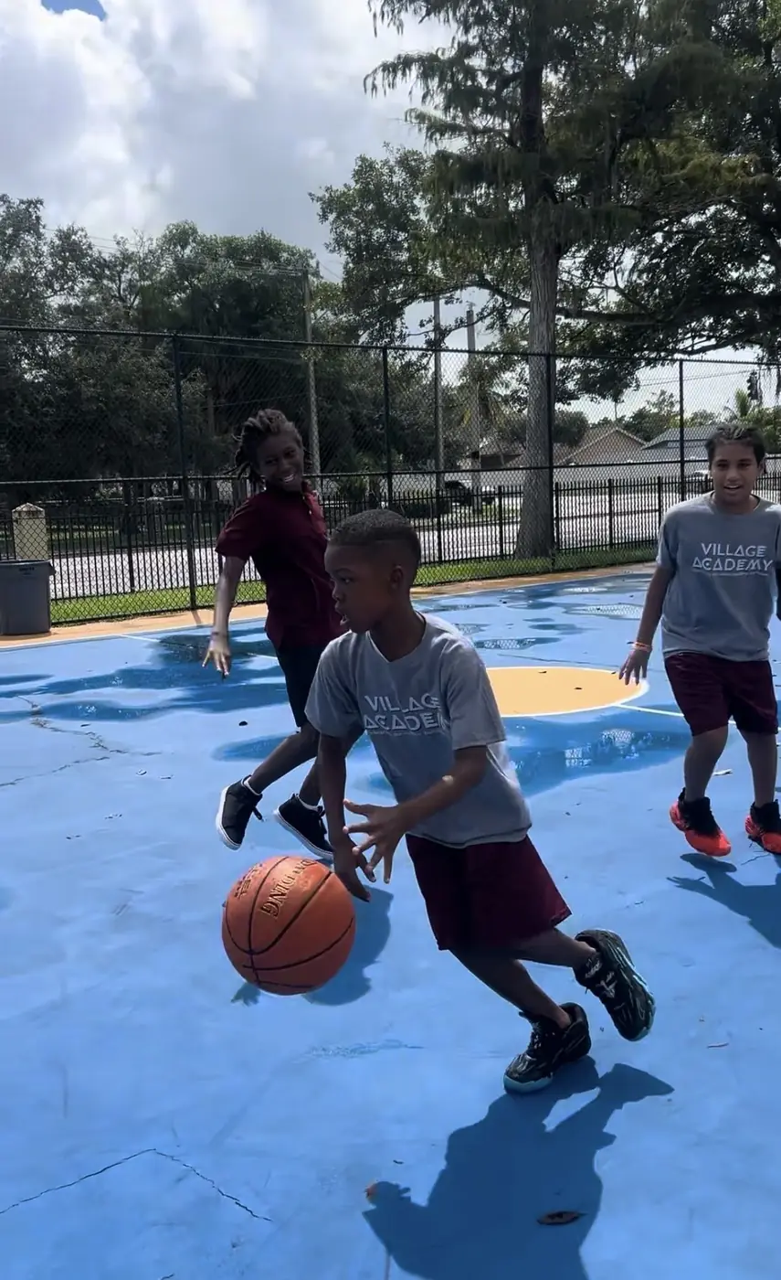 Village Academy students playing basketball outdoors