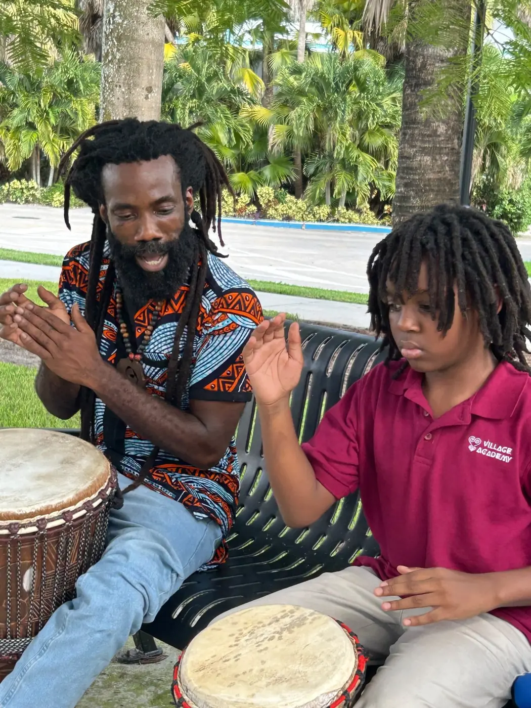 Village Academy student participating in an African drumming experience