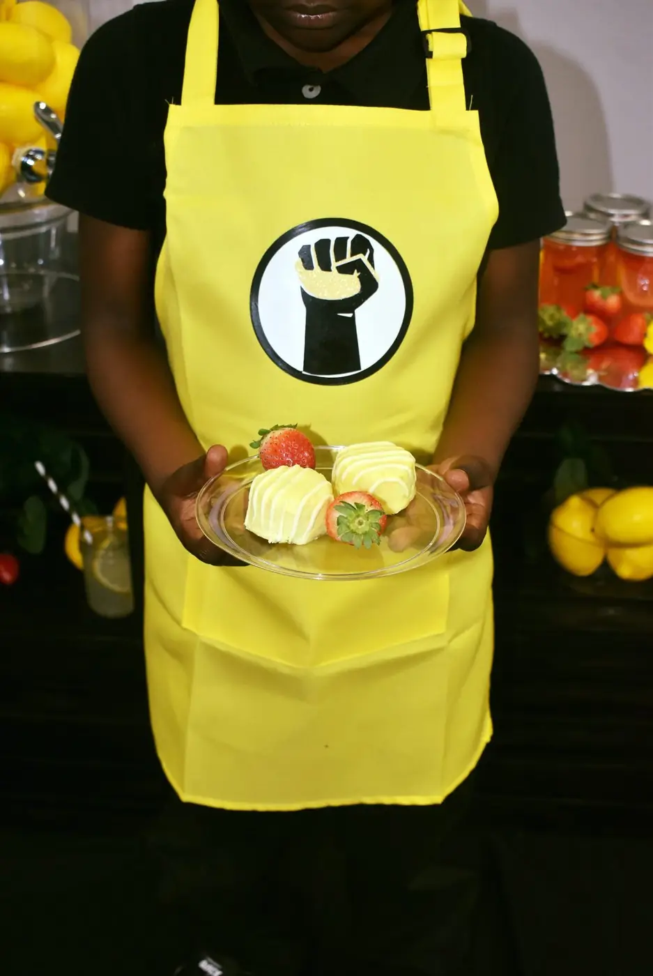 Student wearing The Stand apron presenting a product